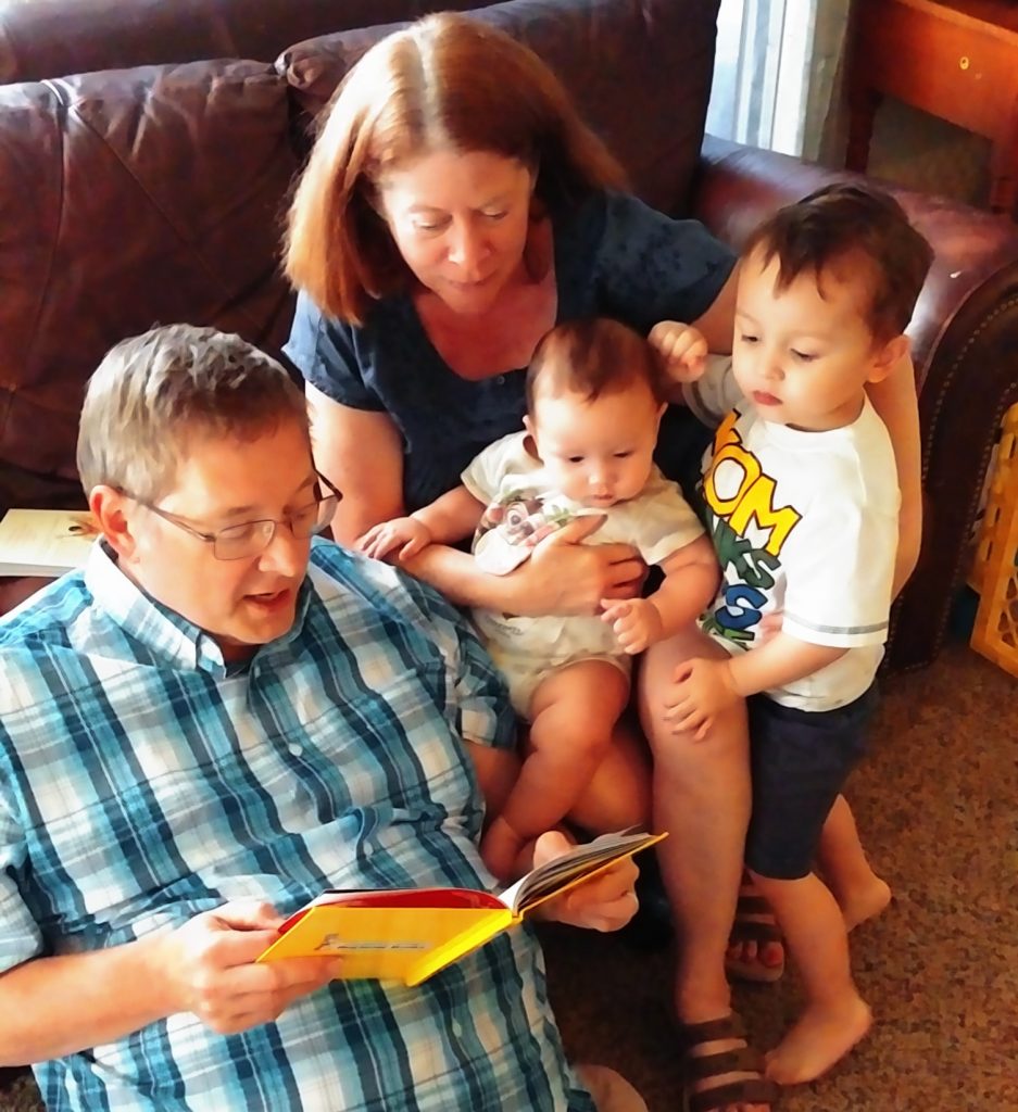 Grandparents reeading to their grandsons
